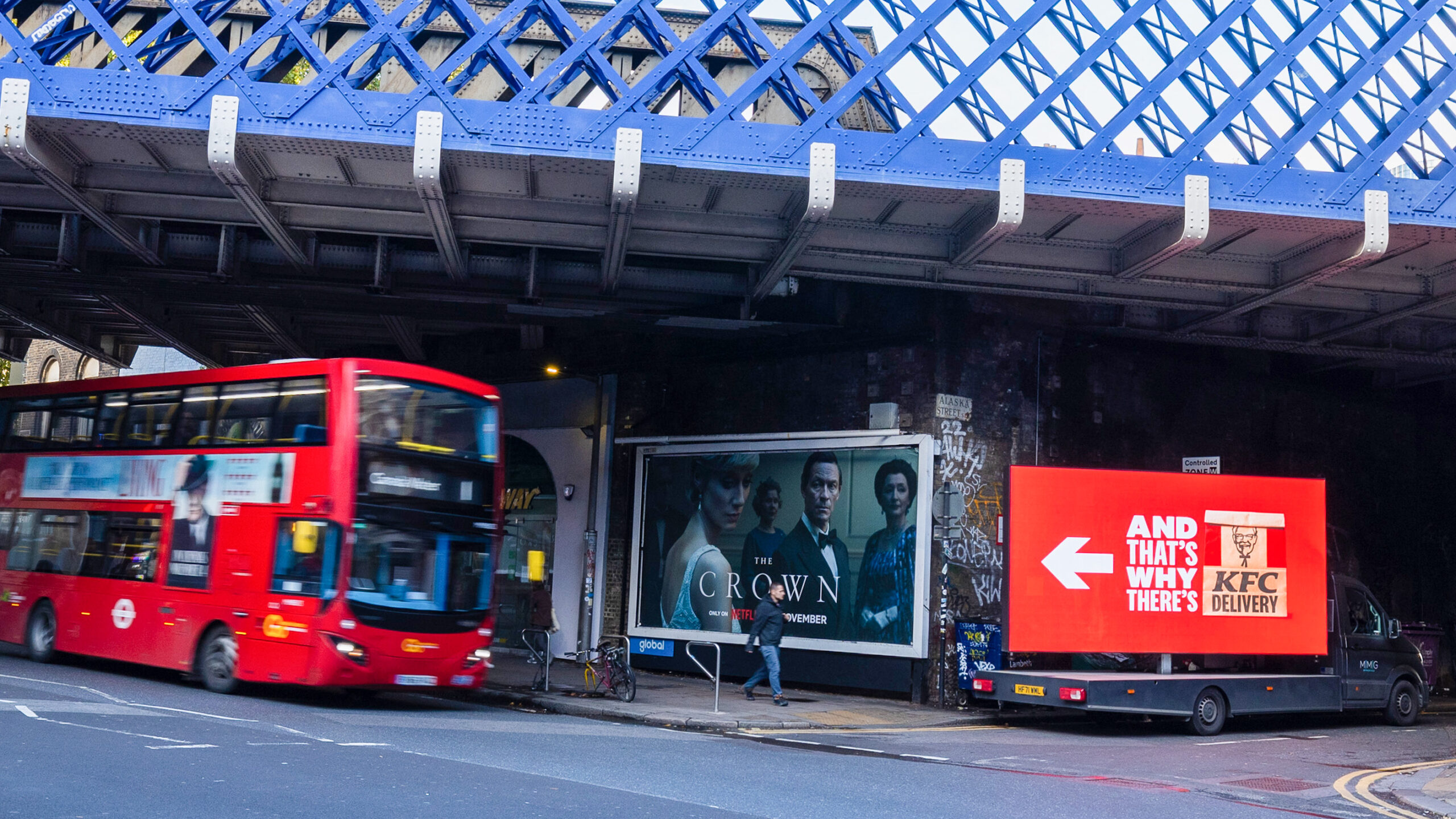 London bus near digital screen and poster advertisement