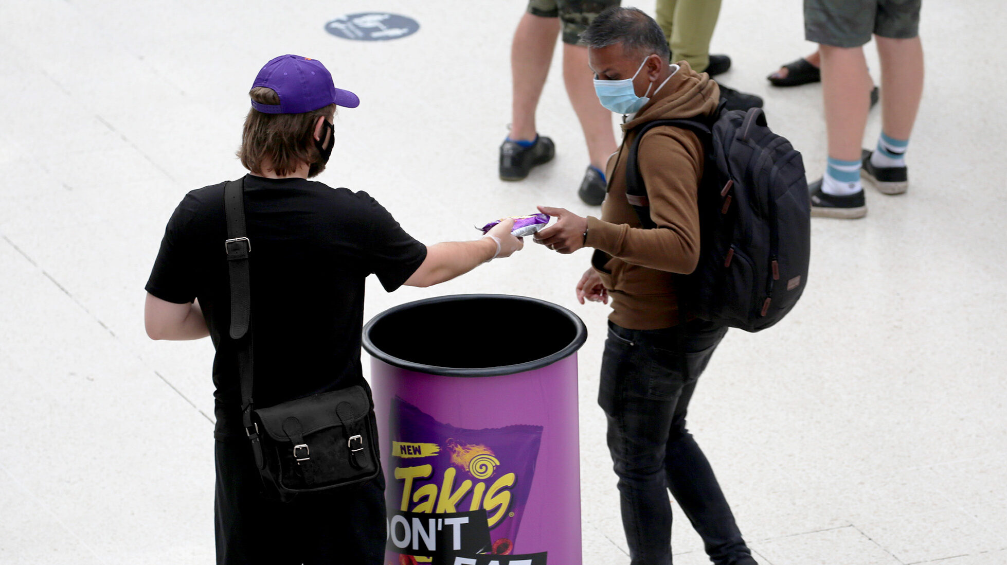 Takis Experiential staff handing out a sample to commuters