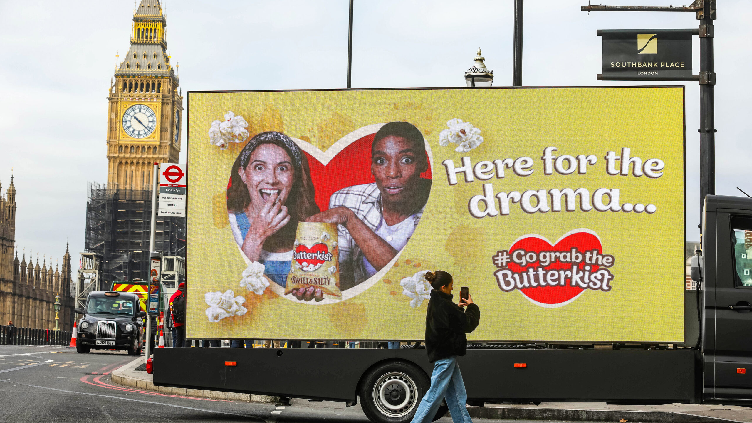Person taking a photo of a Butterkist Digivan in London
