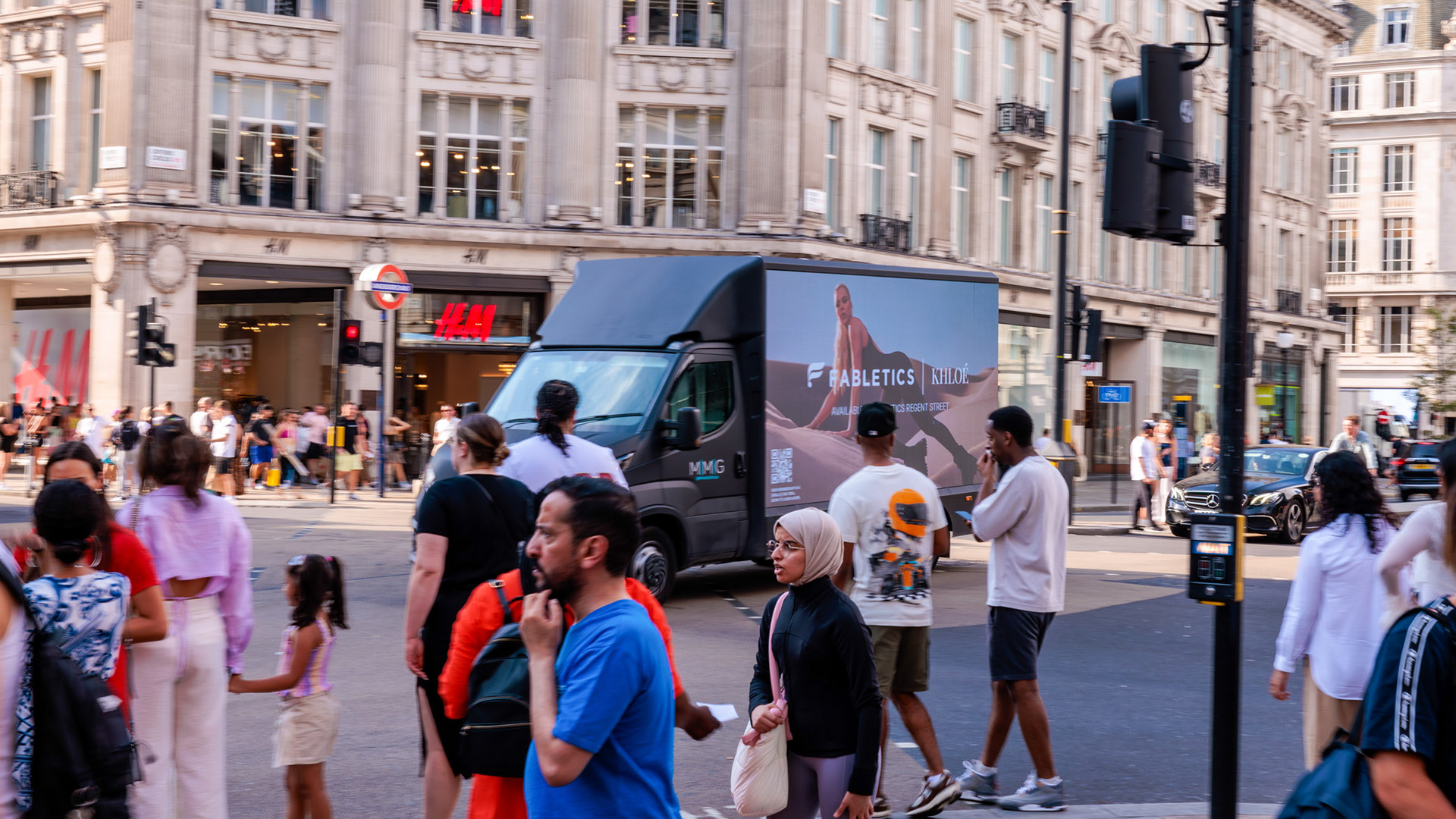 Fabletics triple-sided Digivan activity in London, with audiences looking at it.